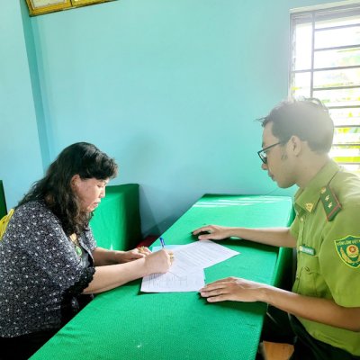 Farmer at a desk sitting across from a government official, while filling out paperwork.