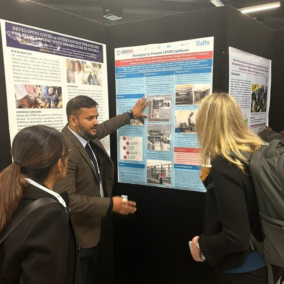 Fahad explaining his posters to two attendees at the Global Health Security Conference.