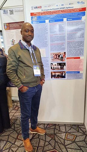 Tizié Thierry Zan-Bi posing with his poster at the conference.